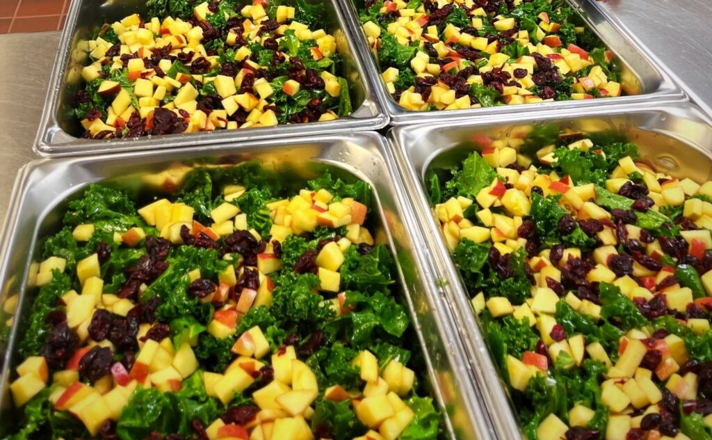 Kale Salad in 4-inch half hotel pans for service.