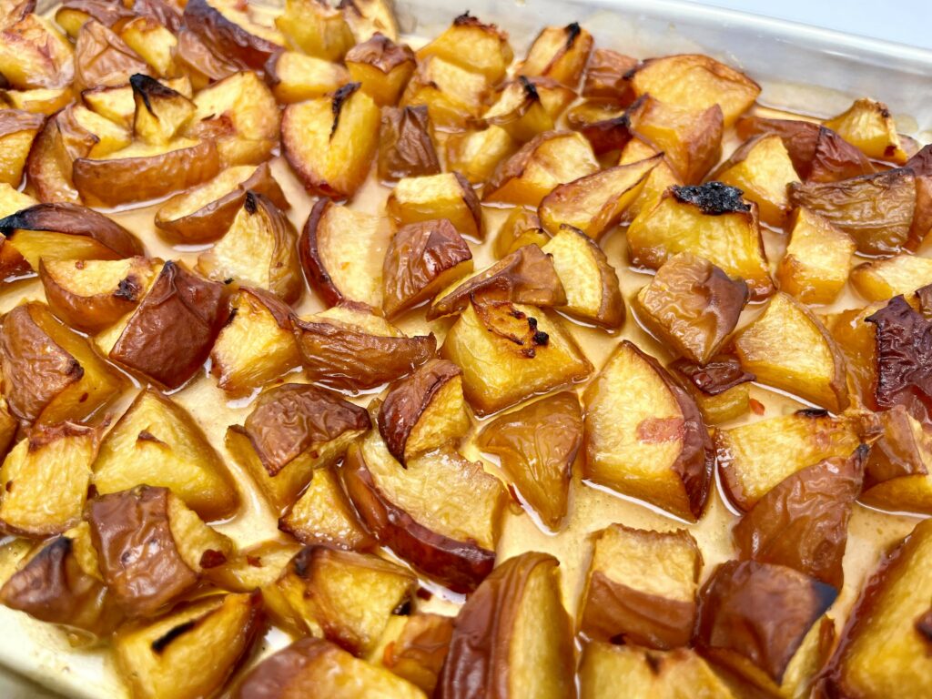 Roasted peaches on pan.