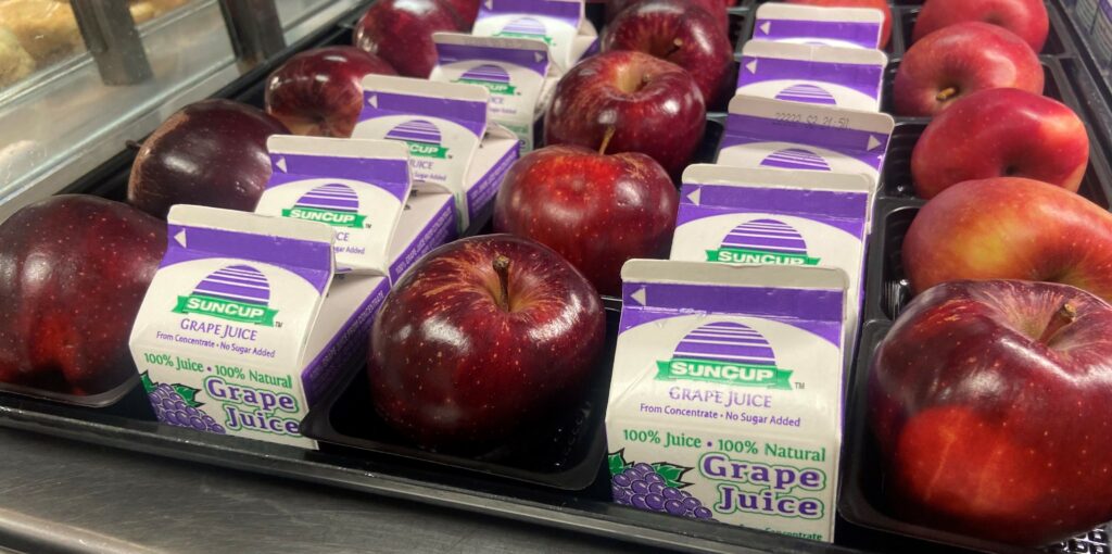 Apples and grape juice on the serving line.