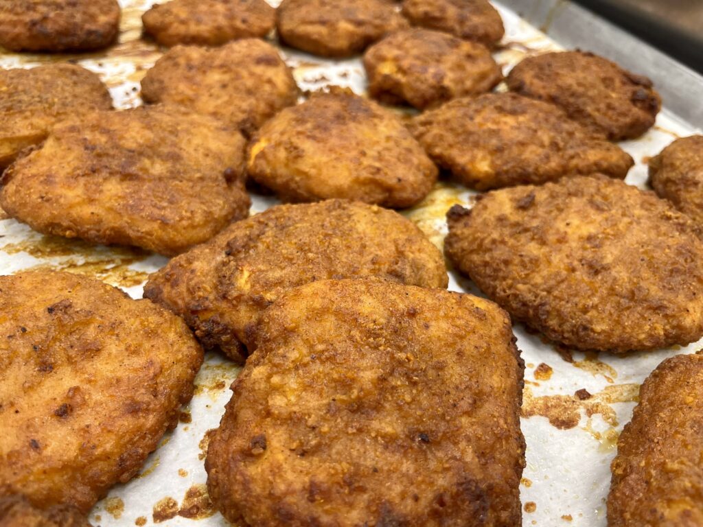 Nashville Hot Chicken Sandwich fillets on a pan.