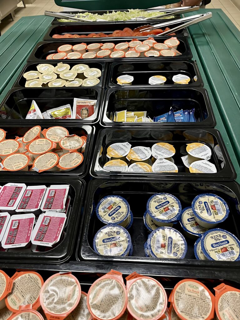 Condiments displayed on lunch line.