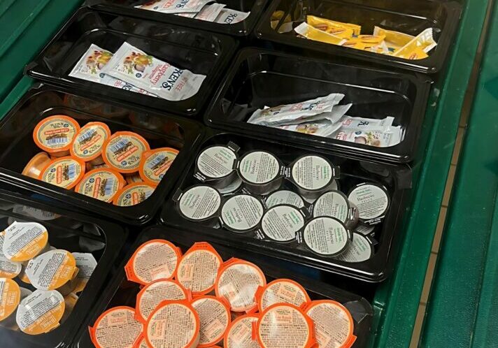 Condiments displayed on lunch line.