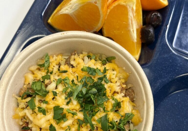 Unstuffed breakfast pepper on school lunch tray with fresh fruit